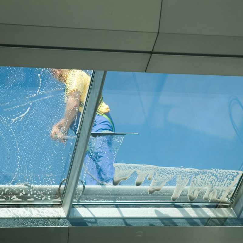 worker cleaning windows
